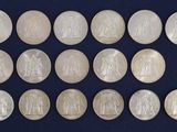 a group of twenty silver coins with the image of jesus on them