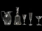 quatre verres à vin et une carafe sur fond noir