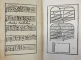 an open book with a drawing of a birdcage and music notes