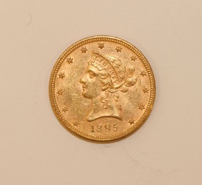 a close up of a gold coin with a woman ' s head on it