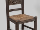 une vieille chaise en bois avec une assise tressée sur fond gris