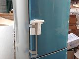 a blue refrigerator sitting in a warehouse next to a pallet