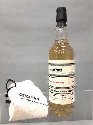 une photo d'une bouteille d'alcool posée sur une table à côté d'un sac