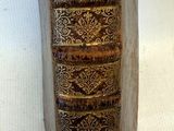 un vieux livre posé sur une table blanche, à côté d'une feuille de papier