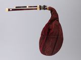 a red bag with a pair of chopsticks sticking out of it