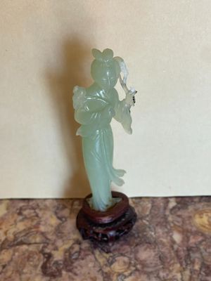 a statue of a woman holding a fan on a table
