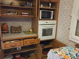 a kitchen with a table, oven, and cabinets in it