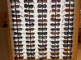 many different shades of sunglasses on display in a store
