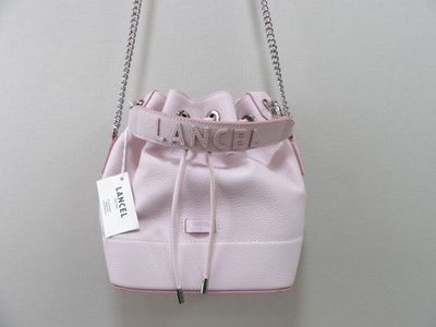 un sac à main rose muni d'une chaîne, accroché à un mur