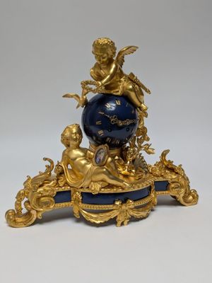 a gold and blue clock sitting on top of a table