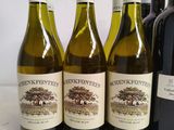 several bottles of wine are lined up on a table