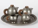 trois théières en argent posées sur un plateau en argent, sur fond blanc