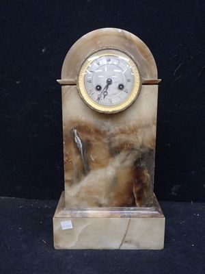 une horloge posée sur un socle en marbre
