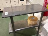une table en métal sur laquelle est posé un bol, dans une pièce