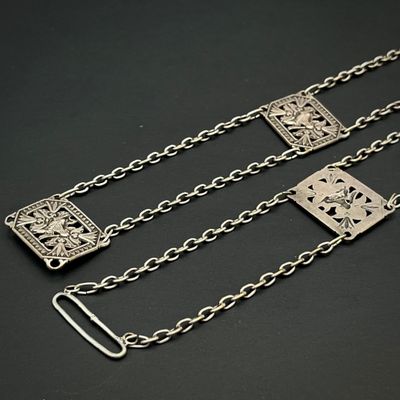un gros plan sur une paire de chaînes métalliques posées sur une surface noire