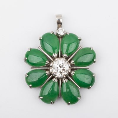 a close up of a green flower shaped pendant with a diamond center