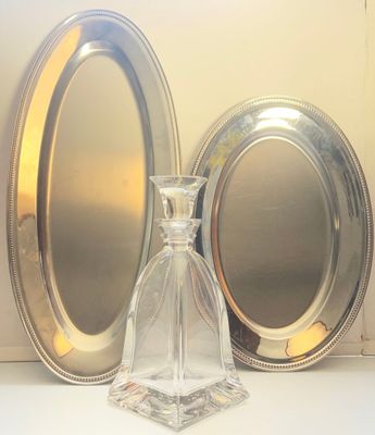 a glass bottle and a silver plate on a table