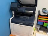 a printer sitting on top of a desk next to a file cabinet