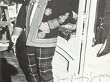 a black and white photo of a man standing in front of a door