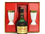 a bottle of courvoisier next to a glass in a box