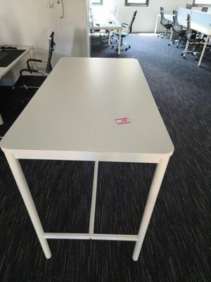 a white table with a pink sticker on it in an office
