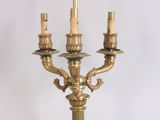 a gold candle holder with three candles on it