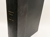 a black book sitting on top of a white table next to a white wall