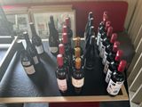 Des bouteilles de vin sont alignées sur une table devant un miroir