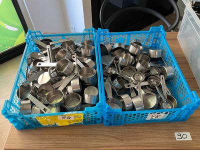two baskets of measuring spoons sitting on a table