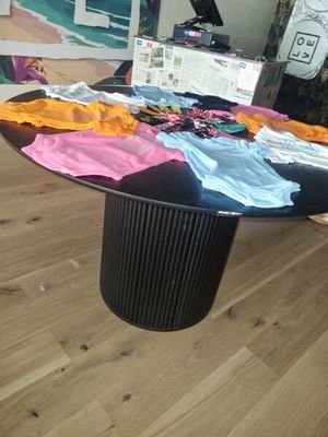 a table that has a lot of t - shirts on it