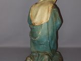 figurine of a woman in a blue robe sitting on a rock
