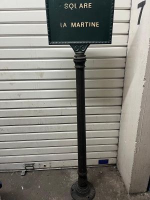 a sign on a pole in front of a garage door
