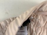 the back of a pink jacket with a tag attached to it