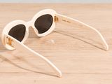 white sunglasses with black lenses on a wooden surface