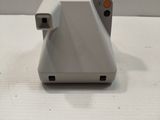 a polaroid camera sitting on top of a white table