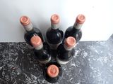 several bottles of wine are lined up on a counter top
