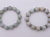 deux bracelets composés de perles blanches et grises sur un fond blanc