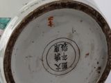 a white vase with a blue and green design on it