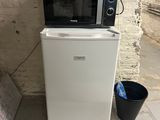 a microwave sitting on top of a small refrigerator