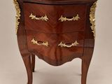 une commode ancienne ornée de détails dorés et dotée d'un plateau en bois
