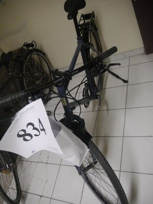 un vélo posé par terre, avec une étiquette de prix accrochée dessus