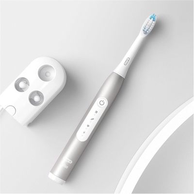 a toothbrush that is next to a mirror on a table
