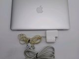 an apple laptop computer sitting on top of a table next to a charger