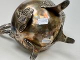 a silver turtle shaped teapot with a tag on it