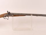 un vieux pistolet avec une crosse en bois, posé sur un socle transparent