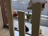 une vitrine sur laquelle est posé un ventilateur, devant une fenêtre