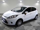 the white ford fiesta is parked in a room with a checkered floor