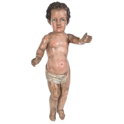 une vieille statue en bois représentant un bébé portant une couche et un pantalon de protection