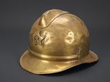 an antique brass fireman ' s helmet on a black background