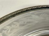 a close up of a silver plate with a bird on it